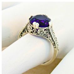 Step into timeless elegance with our Vintage Estate 2.50 Carat Lab Created Amethyst Solitaire Filigree Ring, a piece that beautifully captures the essence of classic charm and modern craftsmanship. This stunning ring features a high-quality, lab-created amethyst stone, measuring an impressive 9 mm, set in exquisite 925 solid sterling silver. The intricate floral designs adorning the filigree work add a touch of sophistication and artistry, making this ring a standout addition to any jewelry coll Vintage Inspired Jewelry, Sterling Silver Filigree, February Birthstone, Filigree Ring, February Birth Stone, Silver Filigree, Purple Hues, Amethyst Stone, Amethyst Ring