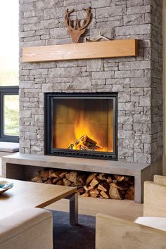 a fireplace with logs and a deer head on the mantle