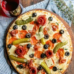 a pizza sitting on top of a wooden cutting board next to a glass of wine