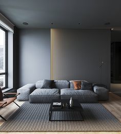 a living room with a large gray couch next to a window