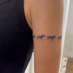 a woman's arm with three horses on it