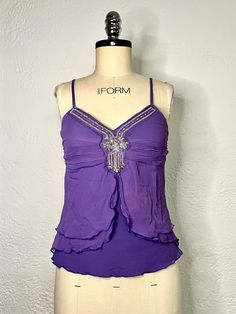 Here we have an exquisite purple blouse with spaghetti straps, a sequin design on the front, and stretch fabric by Anonymous. This women's tank top is vintage from the 90s. Having a sleeveless blouse in your collection is essential for summer. This camisole top can be worn to a formal event or paired with jeans for a more casual look. Thanks for visiting, check out our shop for more vintage and retro finds, Limited stock, so buy now! Measurements: Armpit to armpit: 30 inches Back length: 23 inch Cheap Stretch Purple Camisole, Cheap Purple Stretch Camisole, Fitted Summer Blouse With Built-in Bra, Cami Top With Built-in Bra For Evening, Purple Spaghetti Straps Tank Top For Party, Y2k V-neck Party Top, Y2k Fitted Spaghetti Strap Tops, Y2k Cami Tops For Party, Y2k Style Cami Top For Party