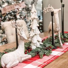 christmas decorations on a table in front of a christmas tree