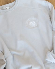 Elevate your style with our latest merch. The Sweatshirt comes in a cream color with a tone-on-tone embroidered Coast + Cove logo. It is lightweight, buttery-soft, and perfectly cozy. Comfortable Cream Cotton Sweatshirt, Casual Cream Tops With Embroidered Logo, Cream Casual Tops With Embroidered Logo, Cream Sweatshirt With Embroidered Logo Relaxed Fit, Casual Cream Sweatshirt With Embroidered Text, Cream Crew Sweatshirt For Spring, Casual Cream Sweatshirt With Embroidered Logo, Casual Embroidered Cream Sweatshirt, Casual Cream Embroidered Sweatshirt