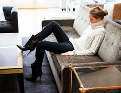 a woman sitting on top of a couch next to a table