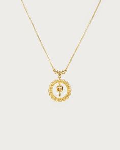 a gold necklace with an elephant in the middle and a circle on it's side