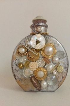 a glass bottle with pearls and other things in it