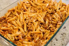 a glass casserole dish filled with pasta and ground beef, ready to be eaten