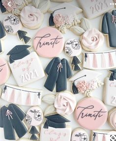 cookies decorated with graduation caps, gowns and flowers are displayed on a white surface