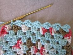 the crochet is being worked on with a knitting needle