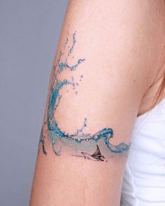 a woman with a tattoo on her arm that has a wave coming out of it