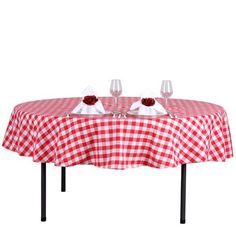 a red and white checkered table cloth with two glasses on it, ready to be served