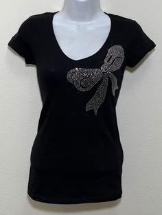 Fabric comprised of 95% cotton and 5% spandex.  Handmade rhinestone t-shirts made in the United States with quality rhinestones. Machine washable. T-shirt style is a fitted V-neck cap sleeve. Size Range:         XXS = 2         XS = 4         S = 6         M = 8         L = 10         XL = 12 Fitted Rhinestone Crew Neck T-shirt, Graphic Tee T-shirt With Rhinestones, Short Sleeve, Embellished Fitted Cotton T-shirt, Fitted Cotton Embellished T-shirt, Cotton T-shirt With Rhinestones And Short Sleeves, Cotton Short Sleeve T-shirt With Rhinestones, Cotton T-shirt With Rhinestones Short Sleeve, Rhinestone Cotton Tops With Short Sleeves, Fitted Crew Neck T-shirt With Rhinestones