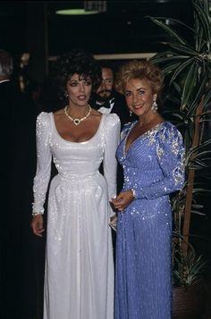 two women standing next to each other in formal wear