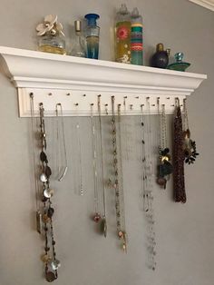 a white shelf filled with lots of necklaces and jewelry hanging from it's sides