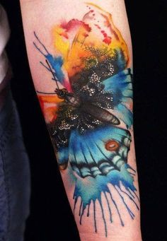 a colorful butterfly tattoo on the arm