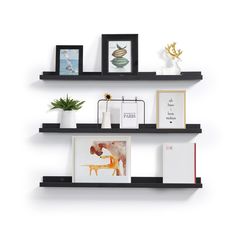 two black shelves with pictures and other items on them, one shelf has an open bookcase