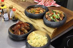 four bowls of food are on a counter