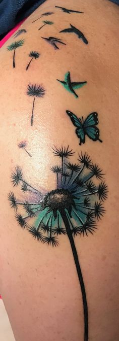 a woman's back with a dandelion tattoo on her stomach and butterflies flying around it