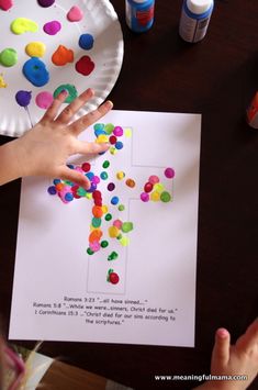 a child's hand reaching for a paper plate with colorful confetti on it