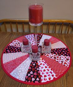 a red candle sitting on top of a wooden table