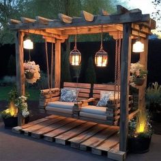 an outdoor swing bed with lights hanging from it's sides and pillows on the back