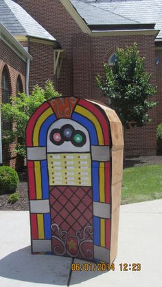 an old fashioned gummy machine sitting in front of a brick building