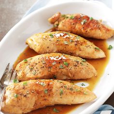 three pieces of chicken on a plate with gravy