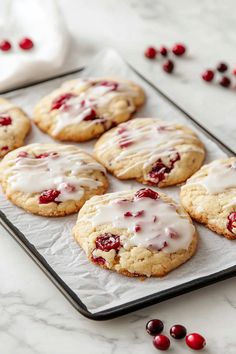 cranberry white chocolate chip cookies with icing on a baking sheet, ready to be eaten