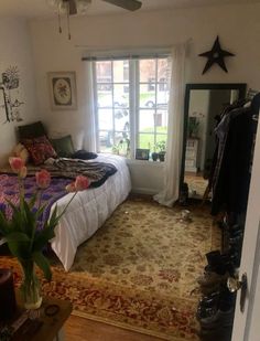 a bed room with a neatly made bed and a large rug in front of a window