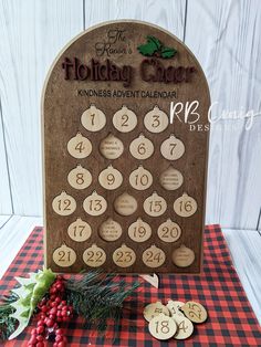 a wooden calendar sitting on top of a red and black checkered table cloth next to christmas decorations