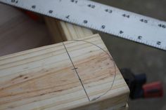 a piece of wood with a measuring tape next to it and a ruler in the background