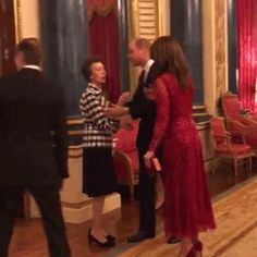 a woman in a red dress standing next to two men