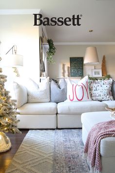 a living room filled with furniture and a christmas tree in front of the couches