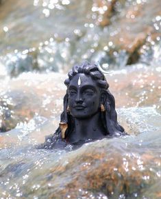 there is a statue in the water that looks like it's floating on his head