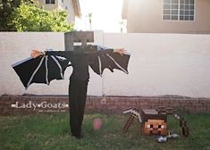 a man dressed as a bat stands in the grass