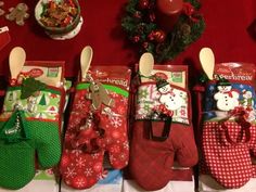 christmas stockings are lined up on the table with spoons and snowman mitts