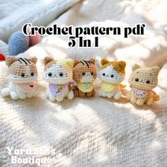 four crochet kittens sitting on top of a white blanket next to each other