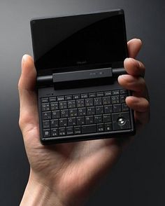 a person holding up a black laptop in their left hand with the keyboard on it