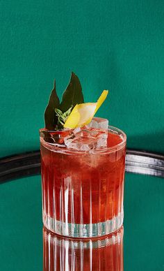 a close up of a drink on a table with a green wall in the background