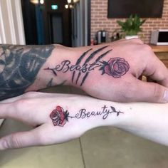 two people with matching tattoos on their arms holding each other's hands and the words beauty written in cursive font