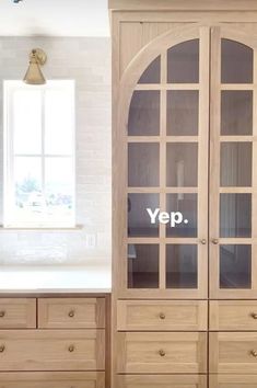 a wooden cabinet sitting next to a window in a kitchen with the words yep written on it