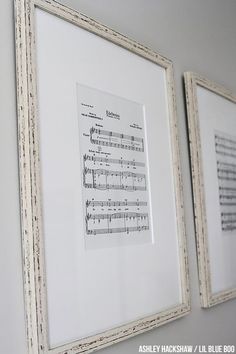 two framed music sheets are hanging on the wall