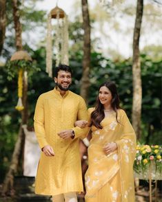 a man and woman dressed in yellow standing next to each other