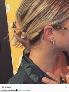 a woman with blonde hair and piercings on her ear