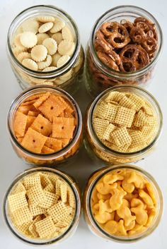 six glass jars filled with different types of snacks