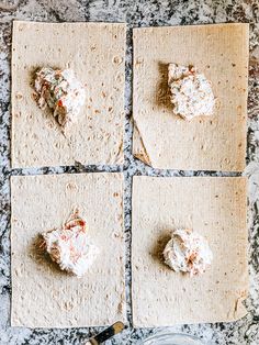 four pita breads with toppings laid out on a counter top, ready to be baked