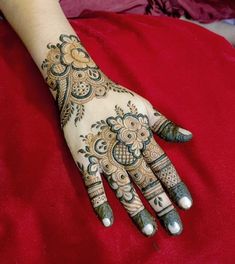 a woman's hand with henna tattoos on it