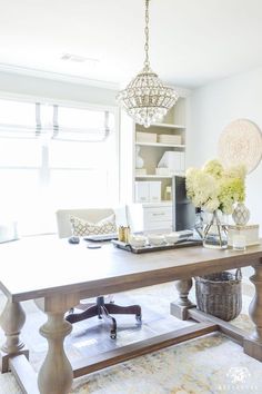 a large wooden table sitting in the middle of a living room next to a window