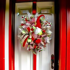 a red and white christmas wreath on the front door